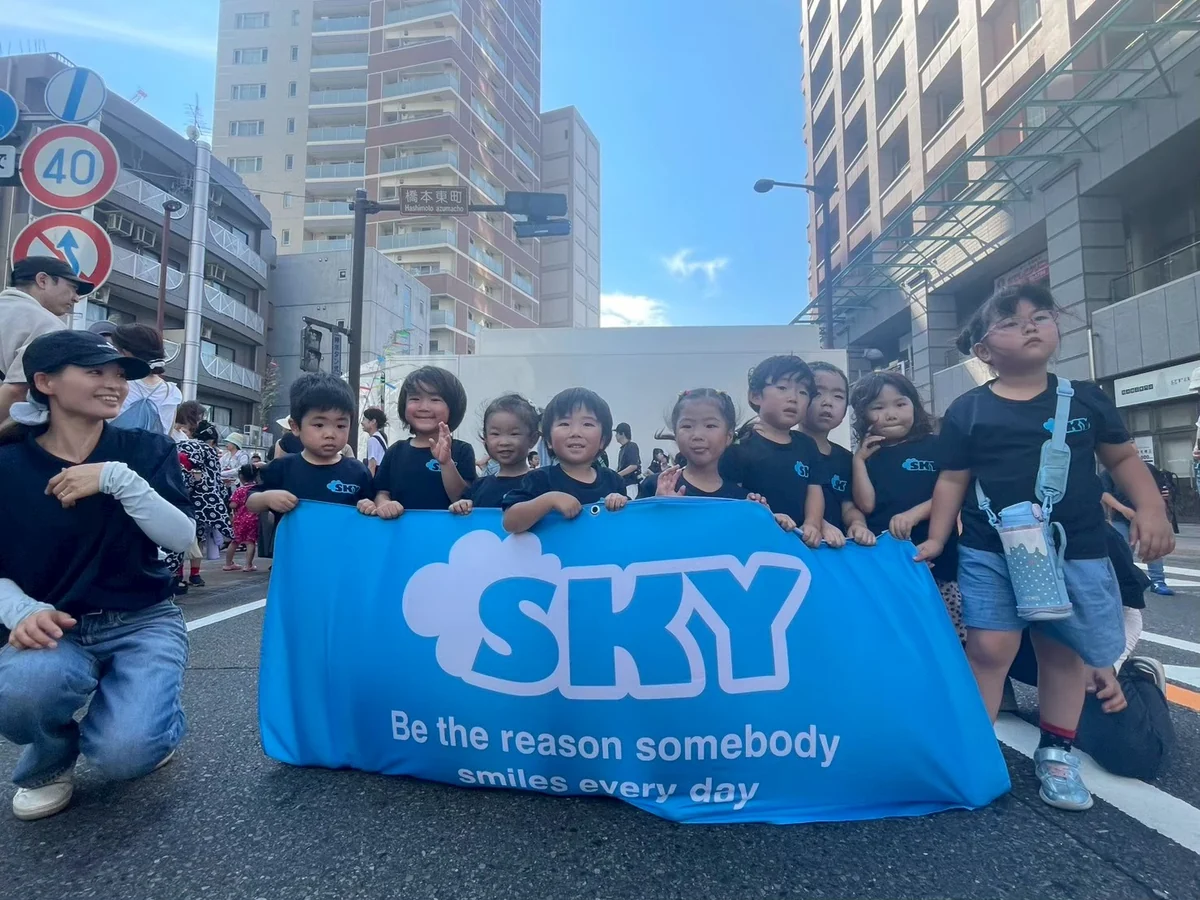 七夕祭りでSKYの旗を持って集まる子どもたち