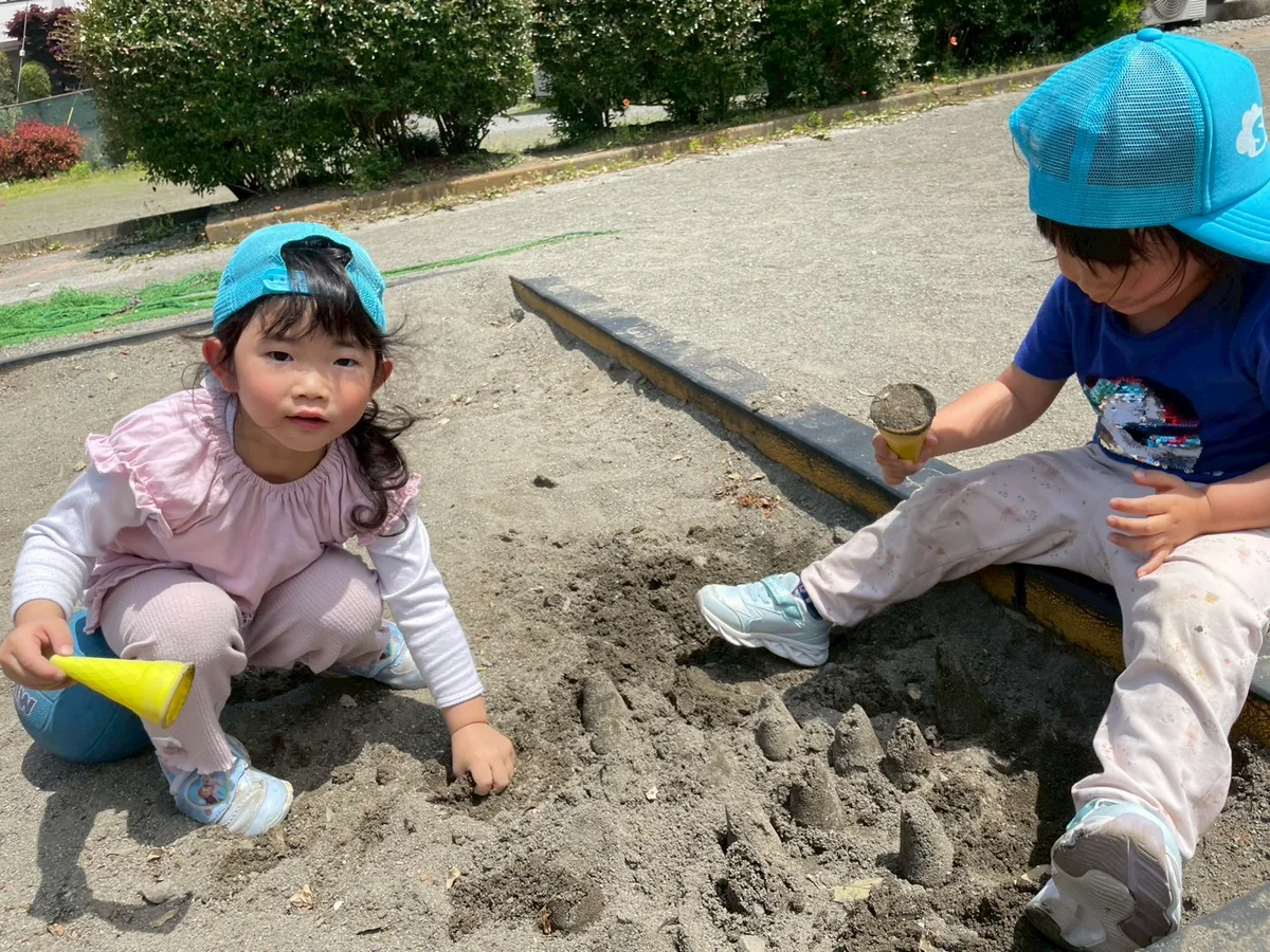 外で砂あそびを楽しむ子どもたち
