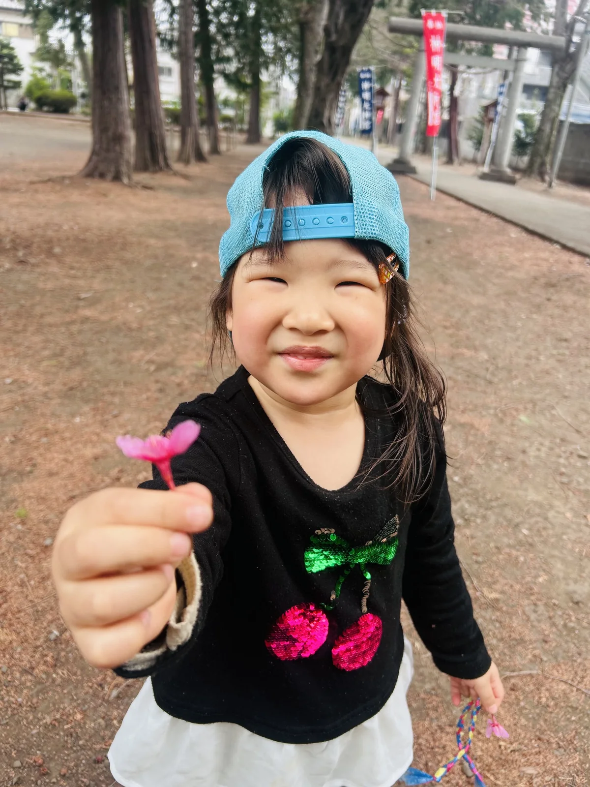 園の外で花を見せて笑う子どもの様子